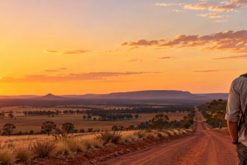 Traveller on a red dirt road at sunset in the Australian outback